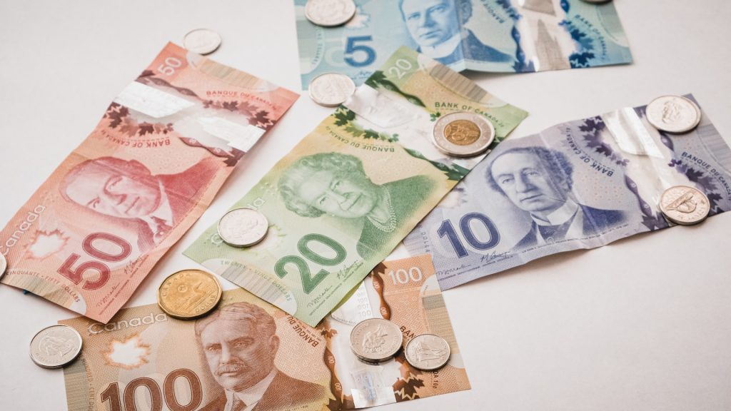 Canadian currency notes and coins on a white background for consolidation purposes.